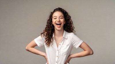 Curly-haired girl smiling with hands on hips
