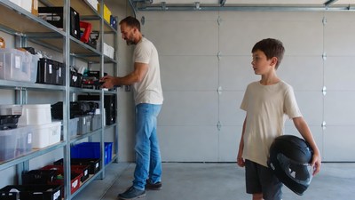 Father and son with helmet in garage