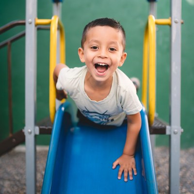 Boy sliding down playground slide