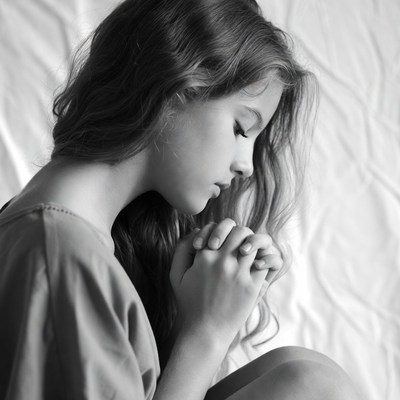 Girl praying with hands clasped
