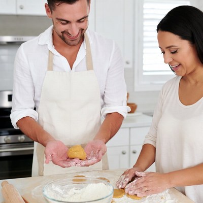 Couple baking cookies in kitchen