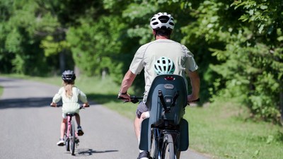 Father biking with daughter in seat