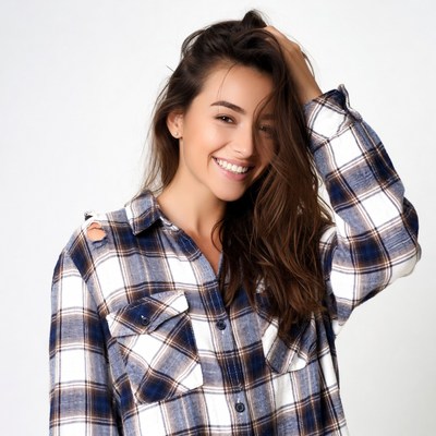 Smiling woman in plaid shirt touching hair