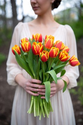 Woman holding orange tulips in forest