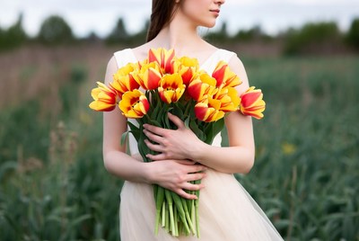 Woman holding orange tulips in field