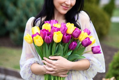 Woman holding yellow purple tulips
