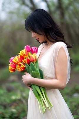 Asian woman holding tulips in forest