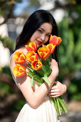 Asian woman holding orange tulips