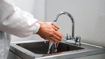 Man washing hands under faucet
