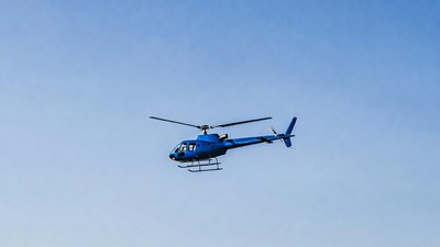 Blue helicopter flying in sky