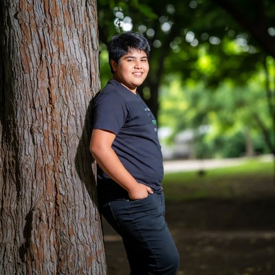 Boy leaning against tree