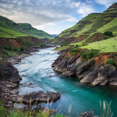 River Flowing Through Green Mountains