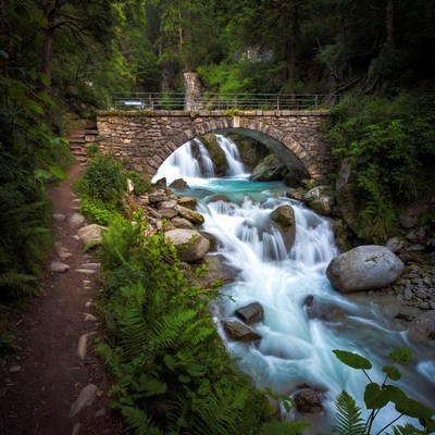 Stone Arch Bridge over Turquoise Waterfall