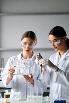Two female scientists using pipette in lab