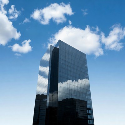 Glass Skyscraper Reflecting Blue Sky Clouds