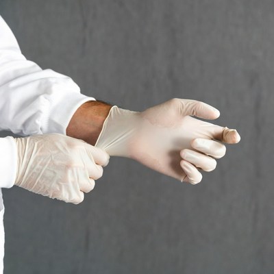 Man putting on latex gloves