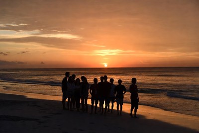 Group silhouettes at sunset beach