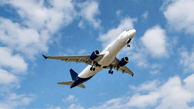 White airplane flying in blue sky