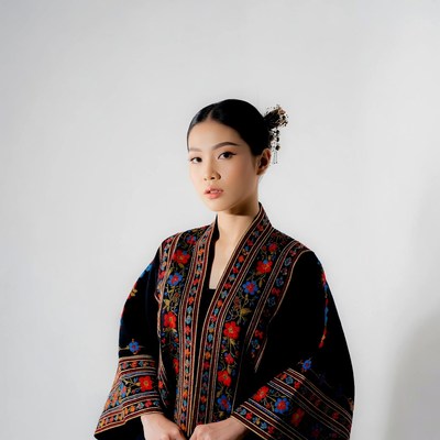 Asian woman in embroidered black jacket