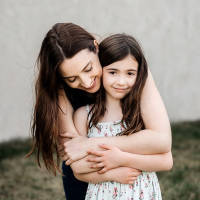 Mother hugging daughter outdoors