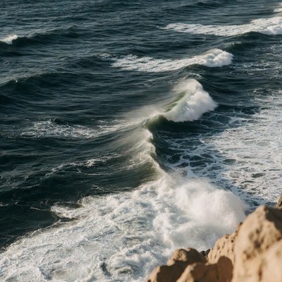 Ocean Waves Crashing Against Rocky Cliff
