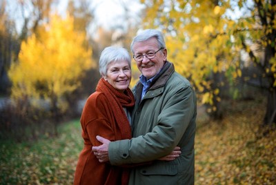 Elderly couple embracing amid autumn trees