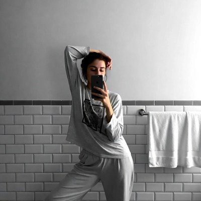 Woman taking selfie in bathroom mirror