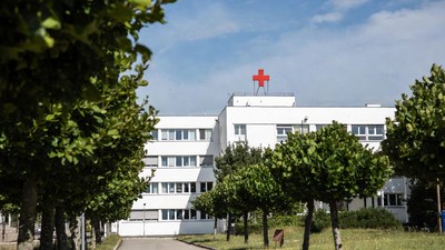 White hospital building with red cross