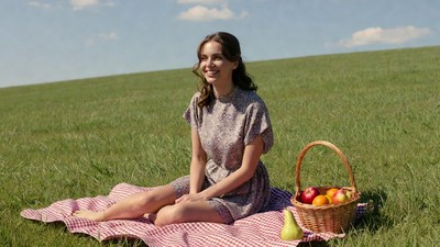 Woman with fruit basket on picnic blanket