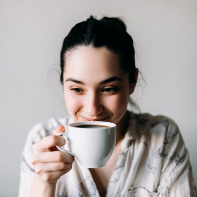 Woman sipping coffee from white mug