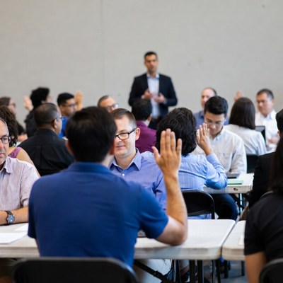 Diverse group raising hands in meeting