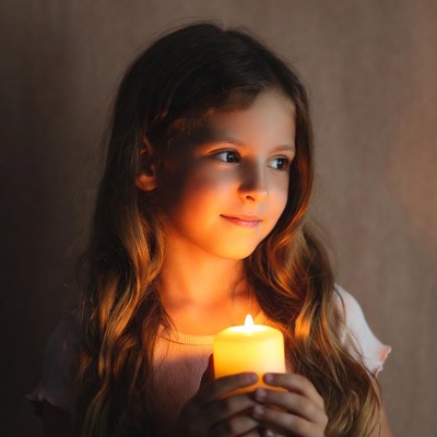 Girl holding lit candle