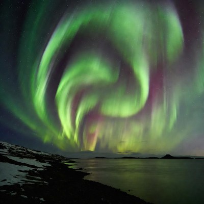 Vibrant Northern Lights over snowy lake