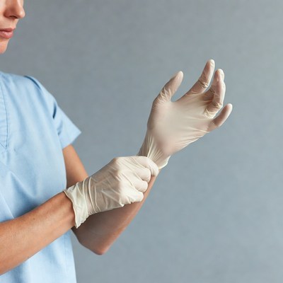 Nurse putting on latex gloves