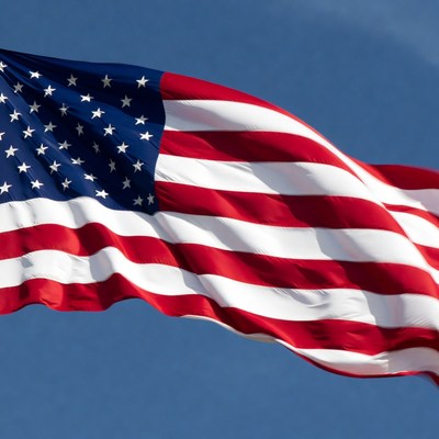 American flag waving against blue sky