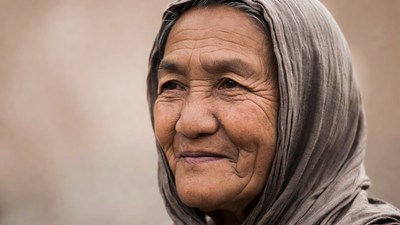 Elderly Asian woman in gray headscarf