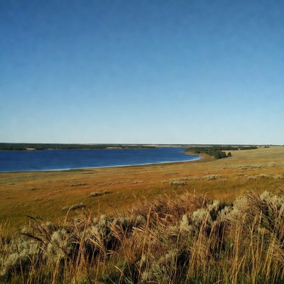 Curving blue lake in golden grasslands