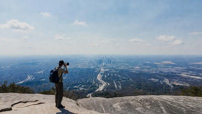 Man photographing city skyline from mountain