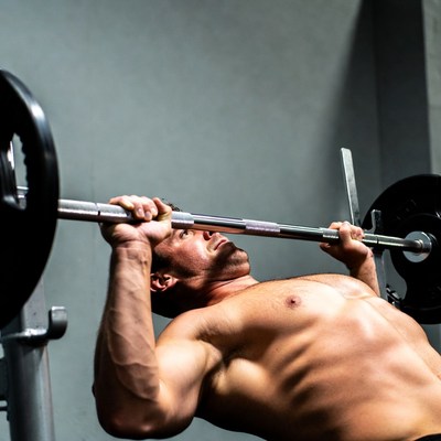 Muscular man bench pressing barbell