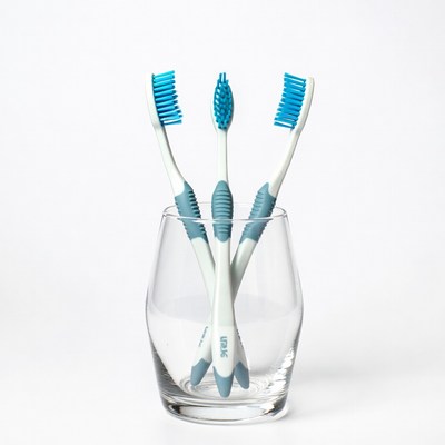 Three blue toothbrushes in glass