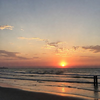 Sunset over beach with waves