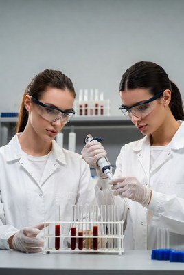 Two women scientists using pipette in lab