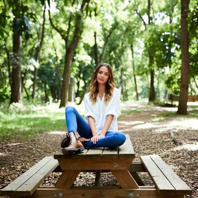 Woman sitting on picnic table in forest