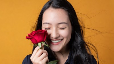 Asian woman holding red rose