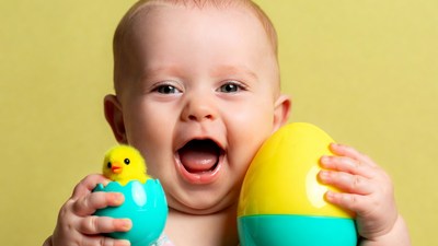 Baby holding Easter eggs and chick