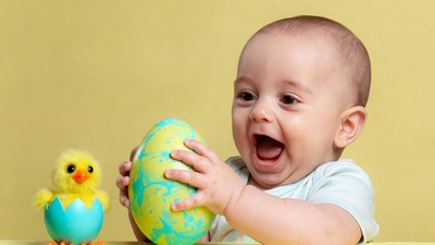 Baby holding Easter egg and chick