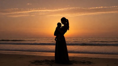 Silhouette mother holding baby at sunset beach