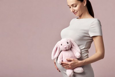 Pregnant woman holding pink bunny