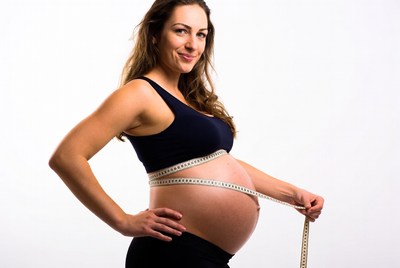 Pregnant woman holding measuring tape