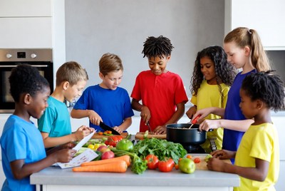 Diverse kids chopping vegetables in kitchen